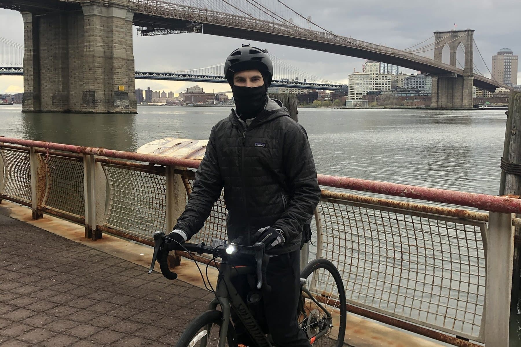 Daniel bundled up for a winter ride with the Diverge, the Brooklyn Bridge behind him
