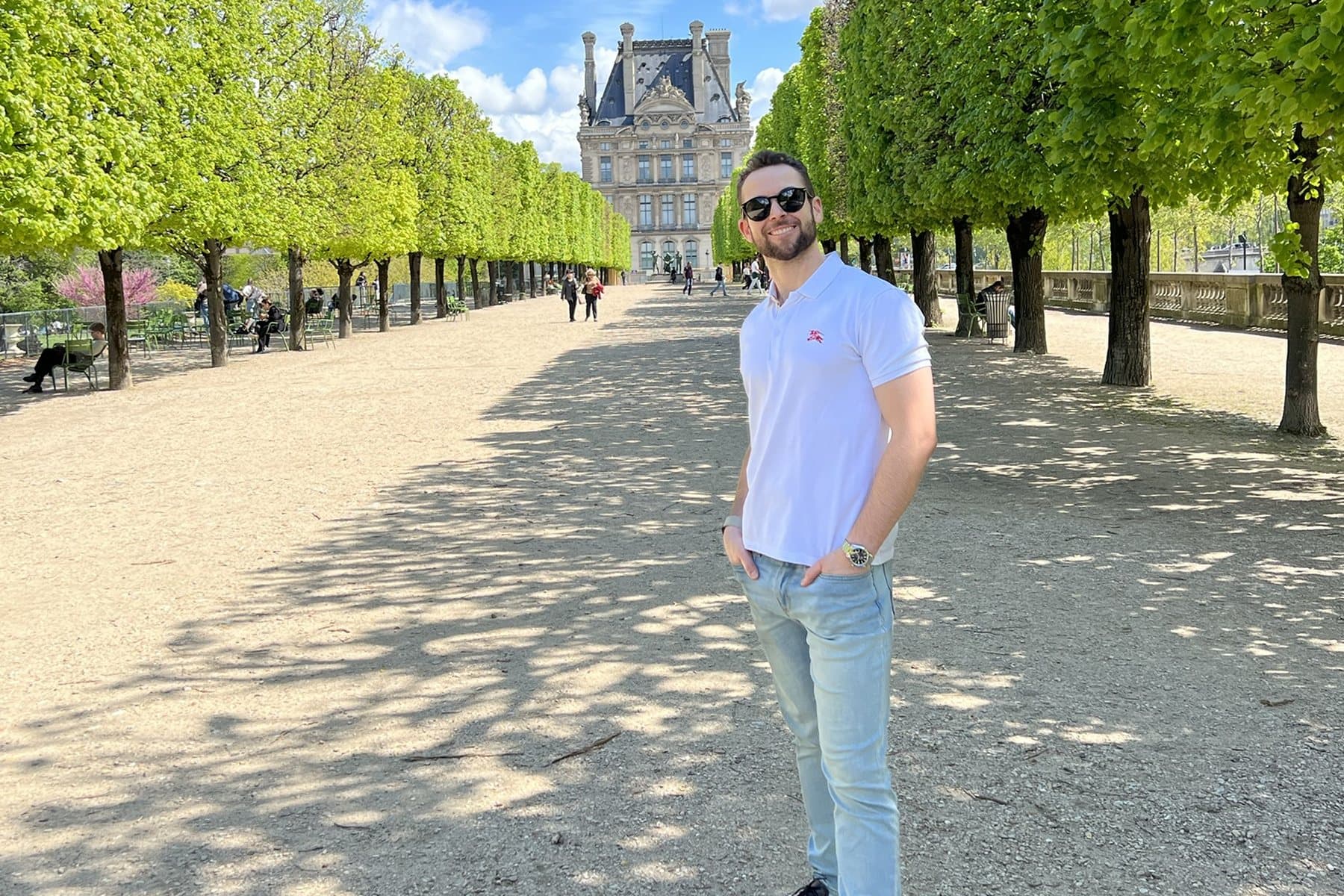 Daniel in the Tuileries Garden in Paris, with the Louvre at the end of the tree-lined allée